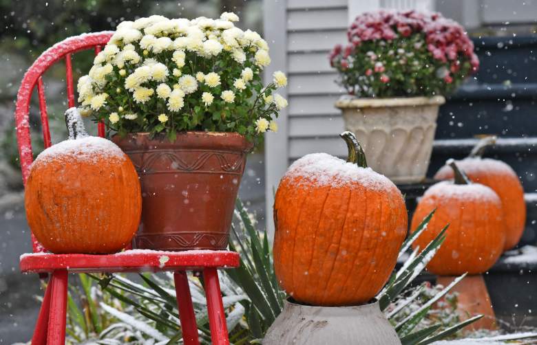 Fresh snow decorates a Halloween display in the yard of a New York on October 27, 2016.