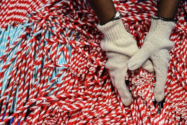A worker packs paper straws manufactured at a factory before delivering them to a local market